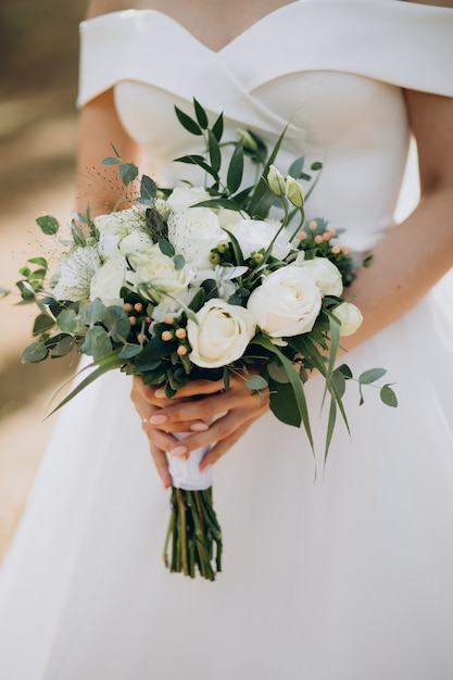 Foto gratuita sposa che tiene il suo bouquet da sposa