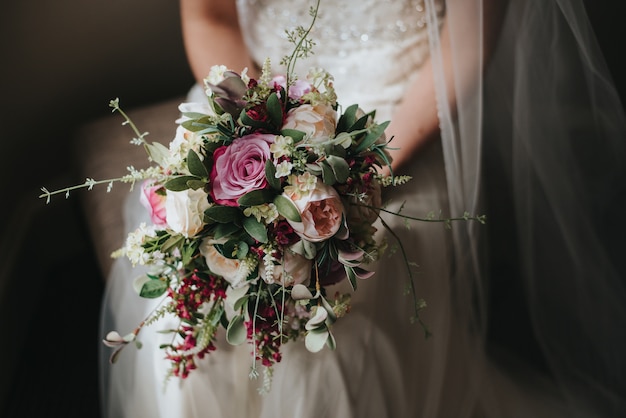 그녀의 결혼식 날의 아름 다운 장미 꽃다발을 들고 신부