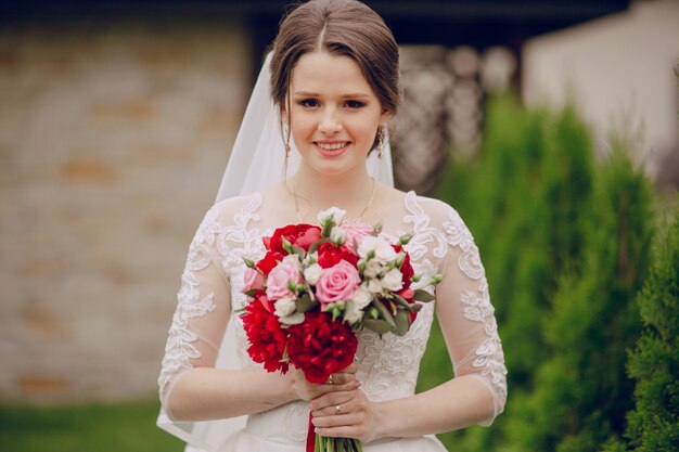Невеста держит свадебный букет с большой улыбкой