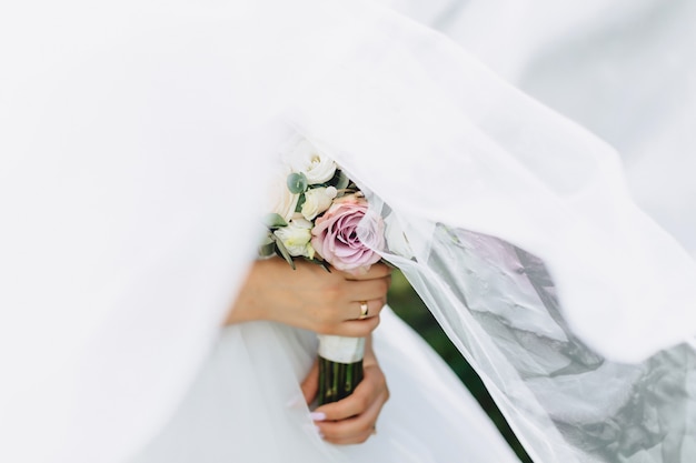 The bride holds a wedding bouquet in her hands