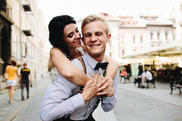 Bride hugging her boyfriend from behind