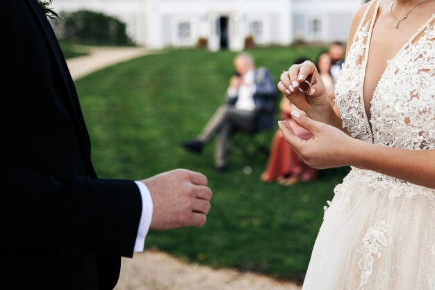 Невеста собирается положить обручальное кольцо на палец жениха