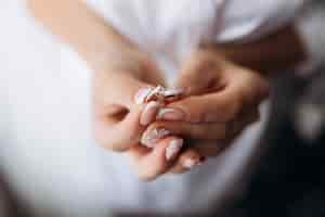 Free photo bride is holding tender engagement ring in her hands