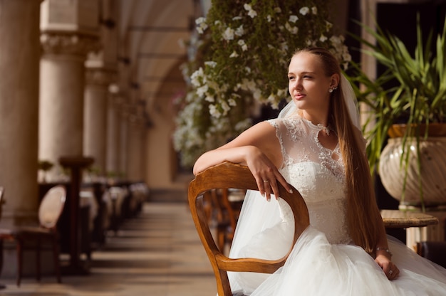 The bride is standing in front of the building