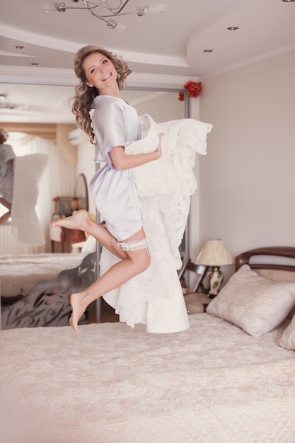 Bride jumping in her bed