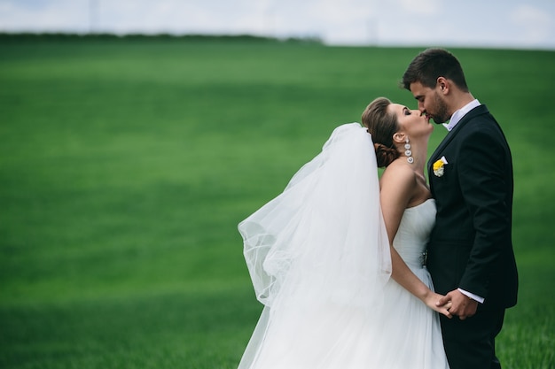 Foto gratuita sposa baciare le labbra del marito all'aperto