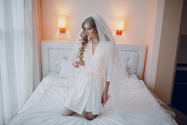 Free photo bride kneeling on the bed