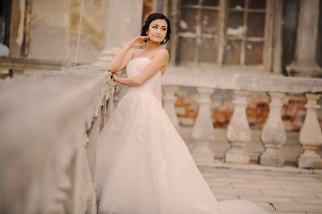 Bride leaning on a stone bench