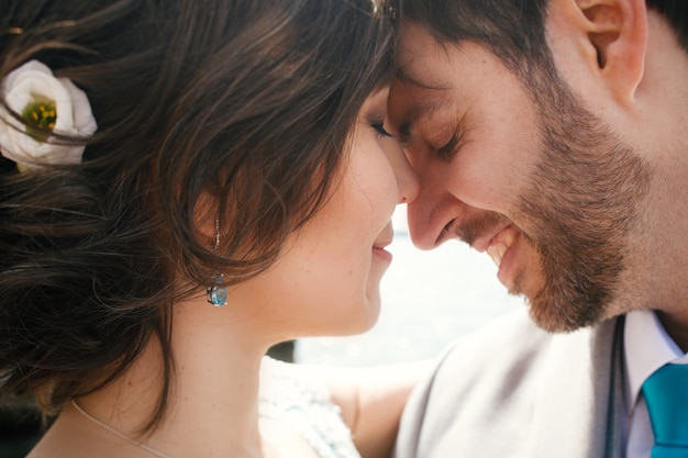 Foto gratuita la sposa si appoggia a toelettatura tenera in piedi davanti al mare