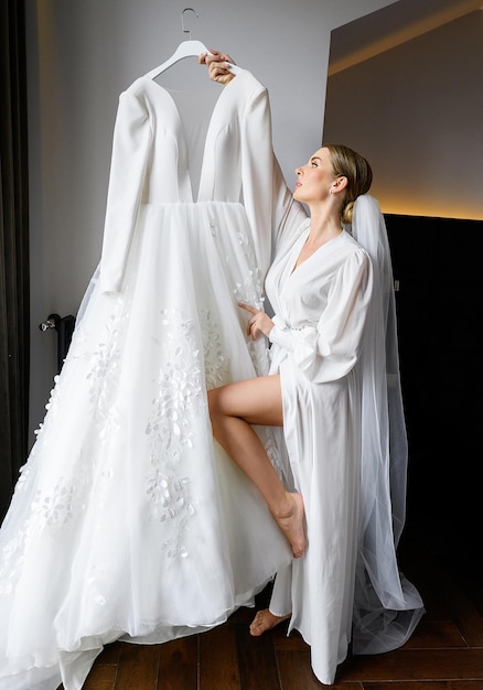 Невеста смотрит на свадебное платье и готовится к церемонии