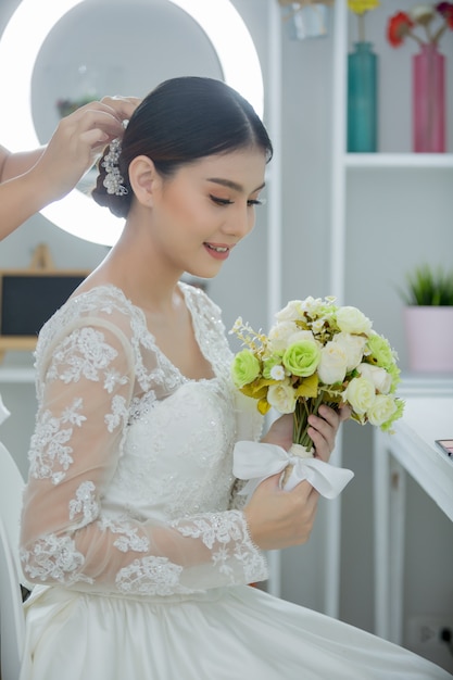 Невеста делает прическу с платьем