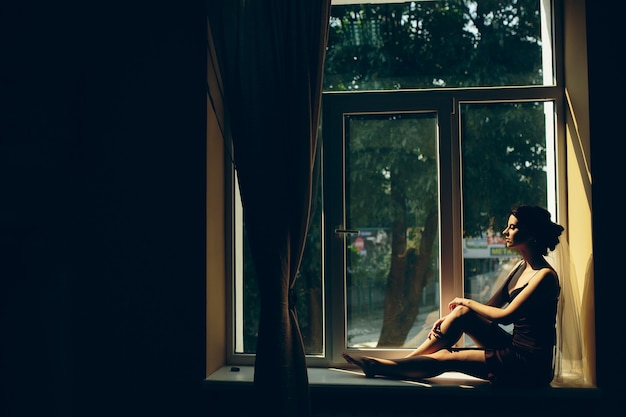 Foto gratuita sposa la mattina seduta sul davanzale della finestra