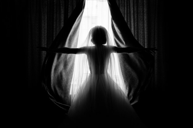 Bride opens the curtains in the hotel room