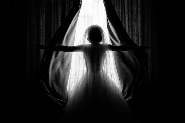 Bride opens the curtains in the hotel room