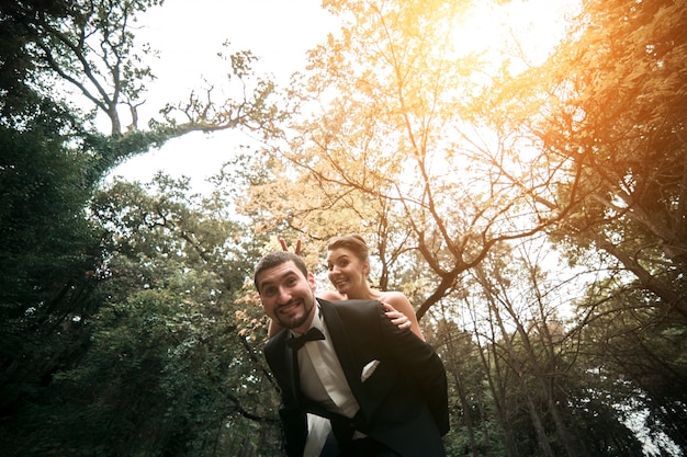 Bride riding a horse on top of her boyfriend