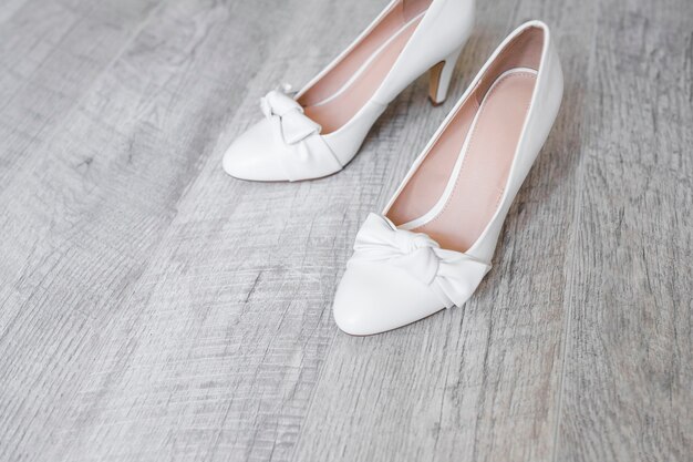 Bride's dress shoes on wooden textured backdrop