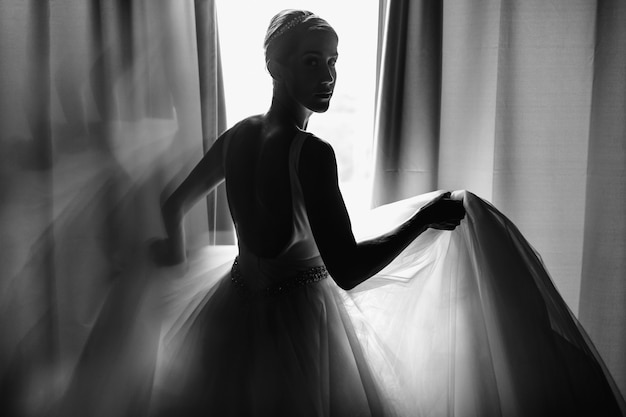 Bride's morning portrait. Bride dressed like a balerina stands b