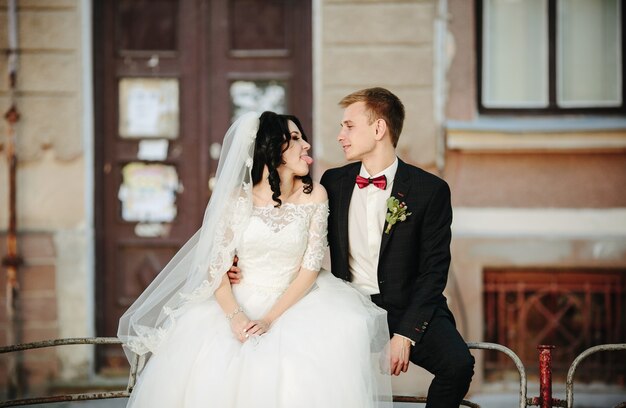 Bride showing tongue to groom