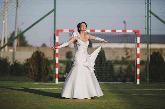 Sposa sorridente in un campo di calcio