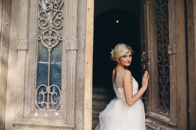 古いドアの前に立っている花嫁