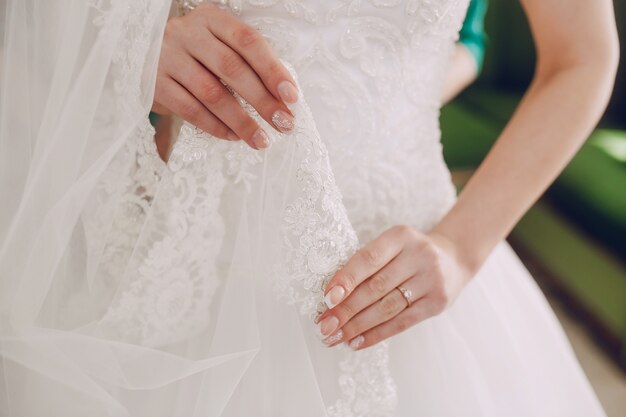 Невеста касаясь его свадебное платье