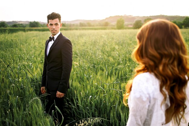 Bride walks to Italian groom standing on green field