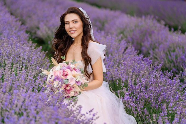 ラベンダーの牧草地でポーズをとるウェディングドレスの花嫁