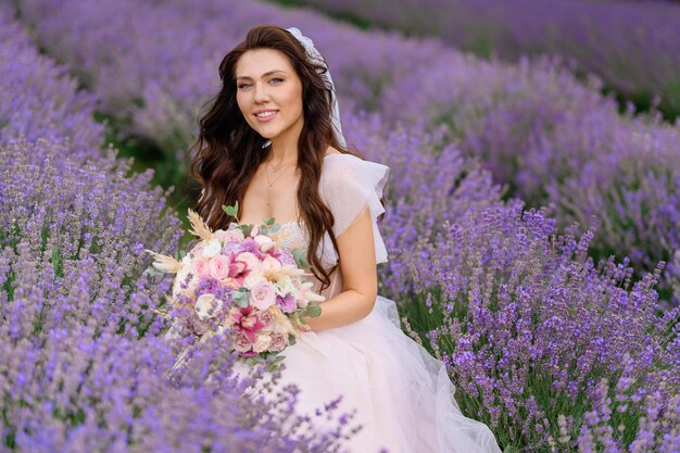 Bride in wedding gown posing in lavender meadow