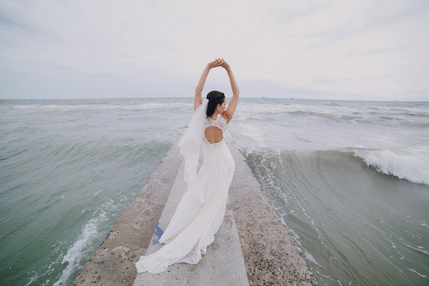 Bride with arms raised at sea