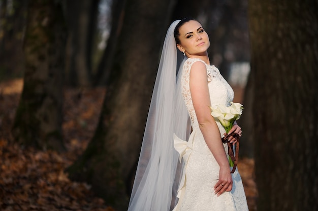 Foto gratuita sposa con un mazzo di fiori in una foresta