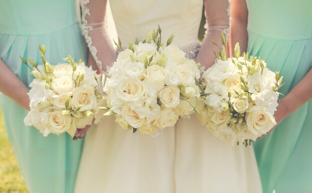 結婚式の花束を保持している花嫁介添人と花嫁