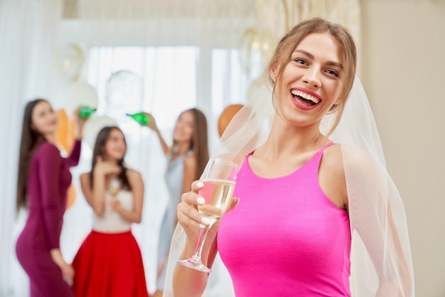 Foto gratuita sposa con champagne che ride all'addio al nubilato