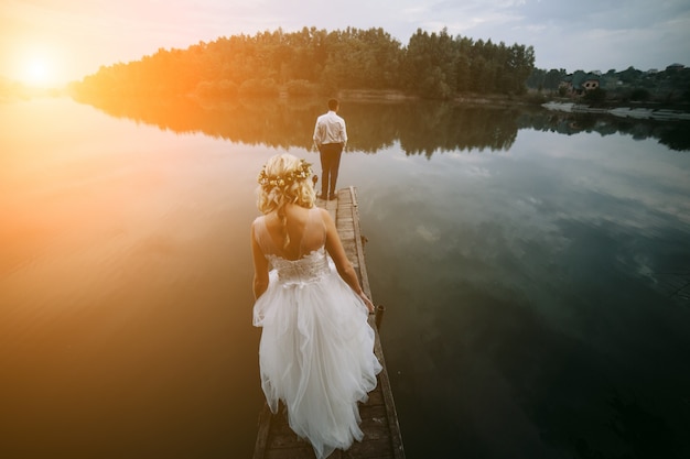 Bride with her husband in front looking at a lake