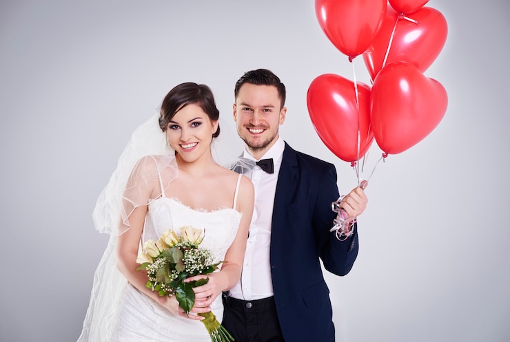 Free Photo bride with roses and groom with balloons