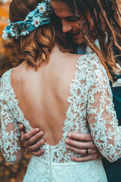 Foto gratuita sposa con l'abito da sposa che abbraccia lo sposo