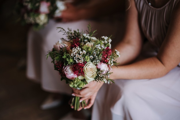 Подружка невесты держит красивый букет роз в день свадьбы