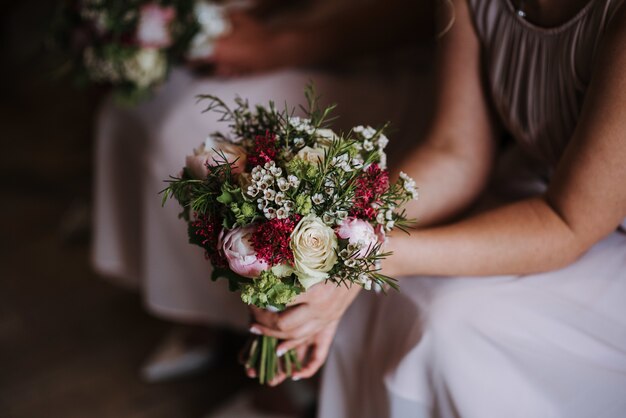 結婚式の日の美しいバラの花束を持っている花嫁介添人