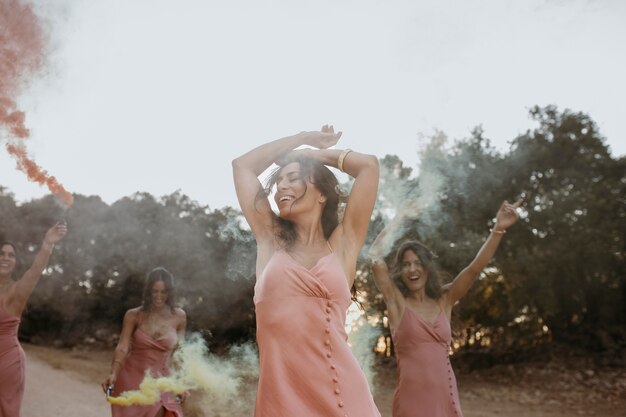 Bridesmaids in pretty dresses celebrating the wedding outdoors