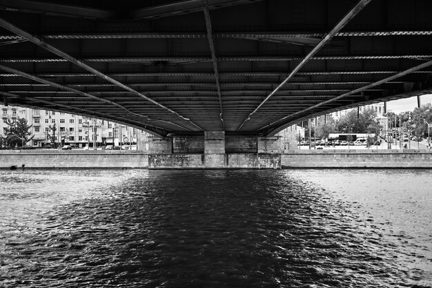 Free photo bridge over the canal with buildings in the background in black and white