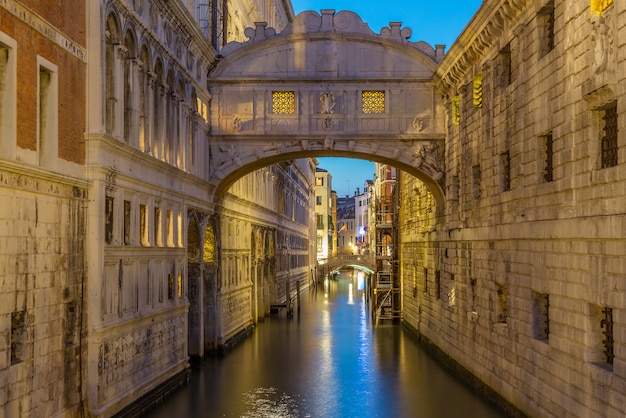 Мост вздохов ponte dei sospiri загорелась на голубом часе ночи захода солнца в венеции, италии. известная достопримечательность. Premium Фотографии