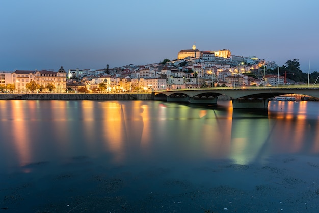 Bridge on the sea surrounded by Coimbra with the lights reflecting on the water in Portugal