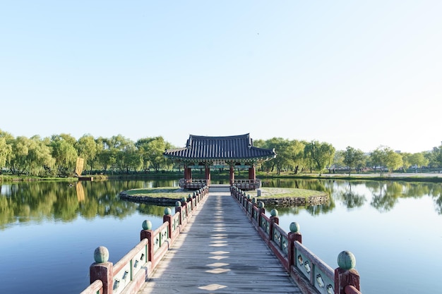Foto gratuita ponte che attraversa un lago fino a un edificio tradizionale circondato da una foresta in corea del sud