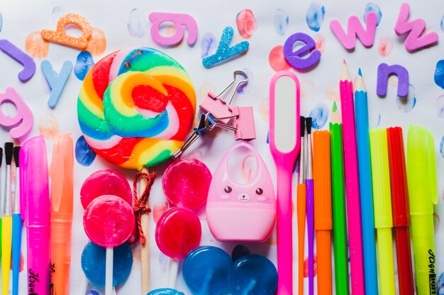 Bright arrangement of school pens and lollipops