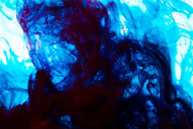Bright blue ink swirls underwater