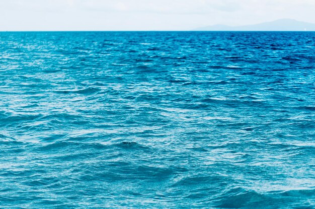 滑らかな波の背景と明るい青い海