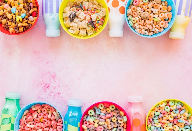 Bright bowls of cereals with milk bottles 