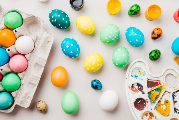 コンテナー、水の色とパレットの近くの着色された卵の明るいコレクション