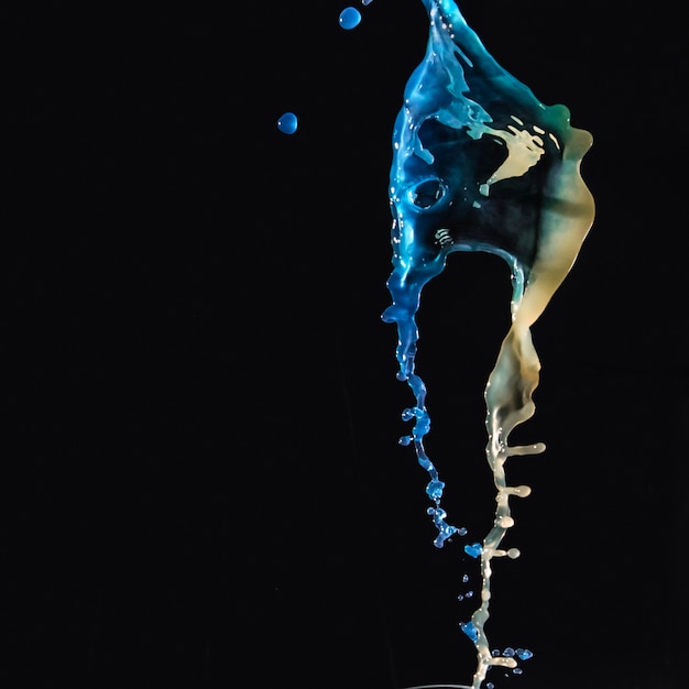 bright colored liquids splashing together on black backdrop