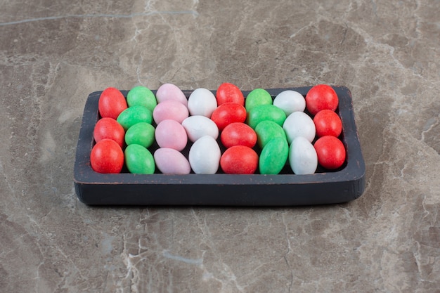 Bright colorful Jelly Beans. Separate colors on a wooden plate.