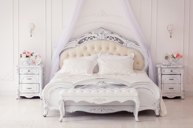 明るく居心地の良いスタイリッシュなインテリアのベッドルーム美しい豊かなアンティーク家具四柱式ベッド